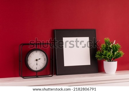 Black picture frame with decorations. Mock up for your photo or text. Place your work, print art, white background, pastel color book. Photo realistic 3d illustration. Red background