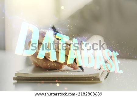 Double exposure of Database word sign with man hand writing in diary on background, global research and analytics concept
