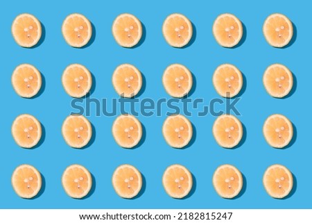 Summer pattern of yellow lemon slices on light-mint background. Minimal summer concept.