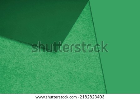 Plain and Textured green papers randomly laying to form M like pattern and triangle for creative cover design idea