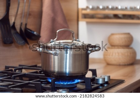 
cook food in a saucepan, pan standing on a gas stove Royalty-Free Stock Photo #2182824583
