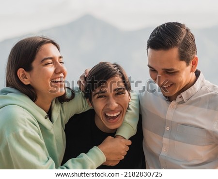 young Latin siblings, laughing jocularly with younger brother in the middle, selective focus  on the girl Royalty-Free Stock Photo #2182830725