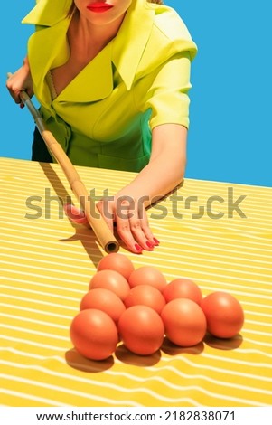 Creative image of female hands playing billiards, hitting egg balls with cue isolated on blue yellow background. Food pop art. Vintage, retro style. Complementary colors, Copy space for ad, text