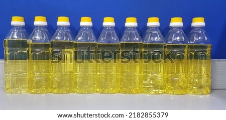 Refined soybean oil in PET bottles are displayed on a table.