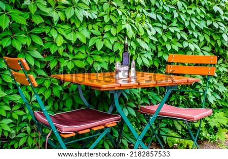 table and chairs at a sidewalk restaurant - photo