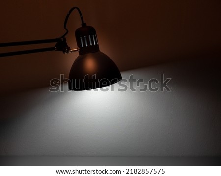 Table gray lamp on a gray background. The lamp shines ha gray background.