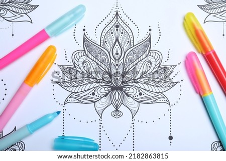 Felt tip pens on antistress coloring page, top view Royalty-Free Stock Photo #2182863815