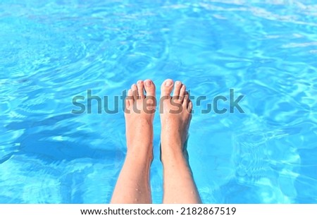 A woman with bare feet above the blue water of a swimming pool