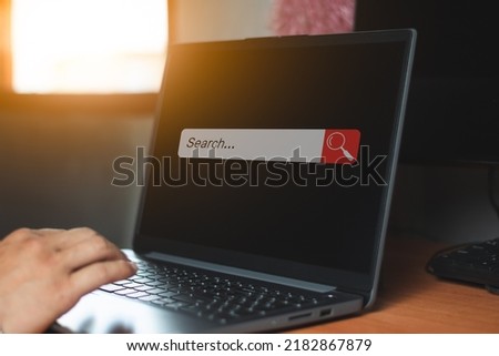 A business man playing laptop computer with search bar, internet and information online,  computer graphic light through window compy space