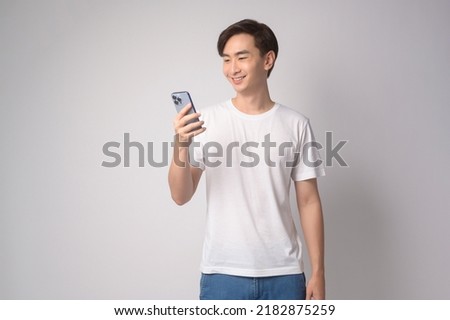 A Young asian man using smartphone over white background, technology concept. 		