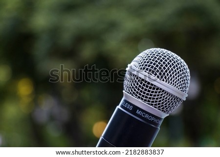 Microphone close-up, outdoor background, daylight