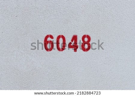 Red Number 6048 on the white wall. Spray paint.
