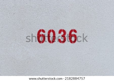 Red Number 6036 on the white wall. Spray paint.
