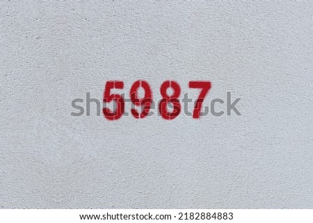 Red Number 5987 on the white wall. Spray paint.
