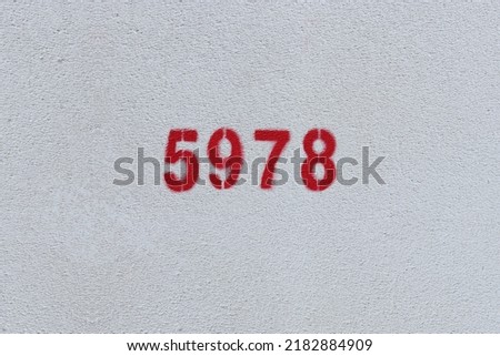 Red Number 5978 on the white wall. Spray paint.
