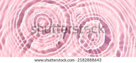 Texture of drops on pink water under sunlight. Top view, flat lay. Banner.
