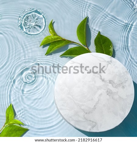 Round empty podium and tropical leaves in water with waves, splashes for presentation of natural cosmetics