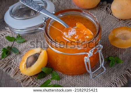 Jam from apricots in a glass jar on an old wooden table Royalty-Free Stock Photo #2182925421