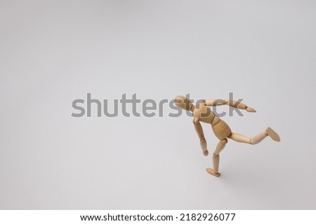 wooden mannequin of a man quickly runs on a white background with copy space