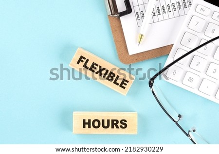 FLEXIBLE HOURS text written on a wooden block with clipboard,eye glasses and calculator Business concept.