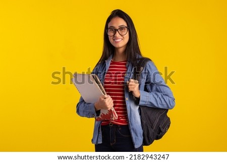 Young student holding backpack and books in studio photo Royalty-Free Stock Photo #2182943247