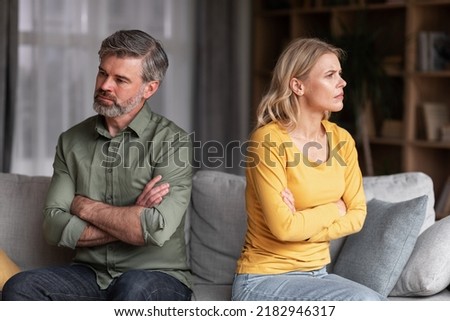 Crisis In Relations. Middle Aged Husband And Wife Offending To Each Other After Argue, Grumpy Spouses Sitting On Couch With Folded Arms, Married Couple Angry After Domestic Quarrel, Free Space