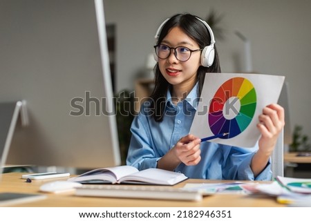 Korean Graphic Designer Lady Making Video Call Showing Color Palette To Computer Webcam Sitting In Modern Office. Successful Career In Design Concept. Selective Focus
