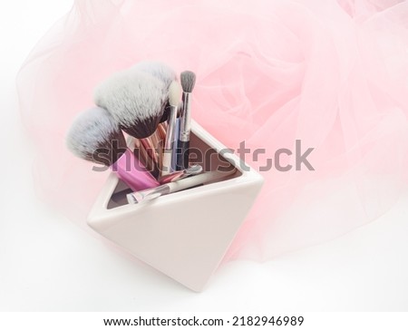several makeup brushes on a light pink background. aesthetics of makeup artist, make-up, holiday, birthday, beauty salon. content shooting for makeup artist