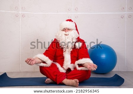Funny fat Santa Claus goes in for sports at home.	