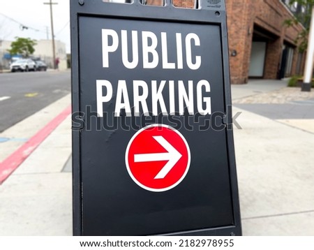 Black Public Parking sign on the sidewalk