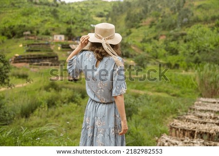 Back view of woman in hat looking at the coffee farm in South Africa