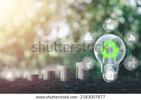 ESG concept of environmental, Green ethical business preserving resources, reducing CO2, Caring for employees, Light bulb and money stack on soil with VR screen ESG icon.	

