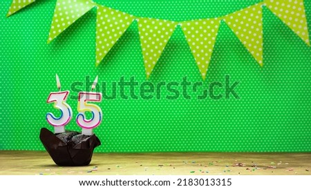 Colorful background happy birthday with decorations festive garlands with muffin on a green background with polka dots. Copy space. Beautiful happy birthday background with burning candles number 35