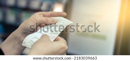 the girl looks at the receipt in the store Royalty-Free Stock Photo #2183039663