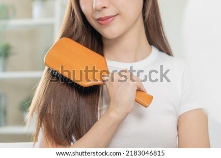 Health hair care, beauty makeup asian woman, girl holding hairbrush and brushing, combing her long straight hair looking at reflection in mirror in morning routine after salon treatment, hairstyle. Royalty-Free Stock Photo #2183046815
