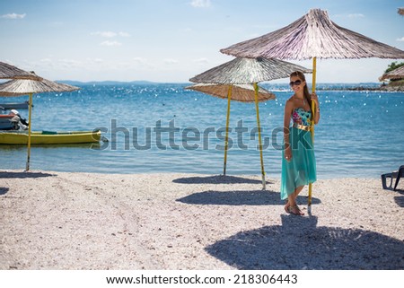 young girl in beach, in the shadow of umbrella, sunbathing