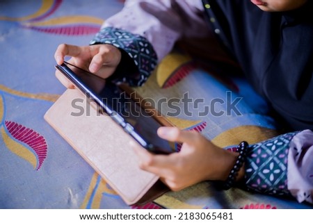 Asian girl playing tablet at home
