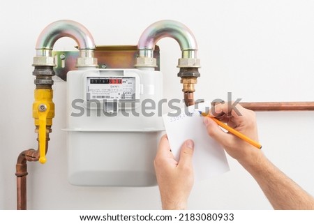 Young man reading the gas meter in the private house, counter for distribution domestic gas. Inflation concept, increasing prices of natural gas.
 Royalty-Free Stock Photo #2183080933