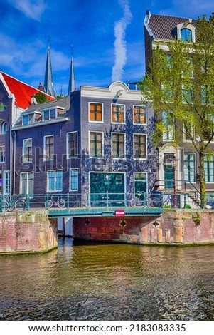 Romantic Amsterdam River Canal For Transportation and Boat Cruises For Guests and Visitors Along Arched Bridges in Amsterdam.Vertical Orientation Royalty-Free Stock Photo #2183083335