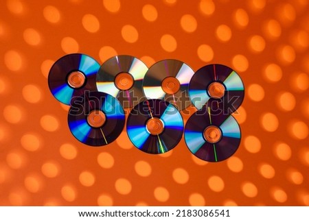 Variety of Arranged CD Disks or DVD Disks on Orange Background With Different Round Circular Dotted Patterns or Masks.Horizontal Image Composition