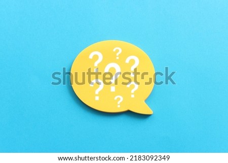 Top view image of sticky note and question mark over textured paper