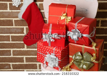 Christmas presents on chair on brown brick wall background