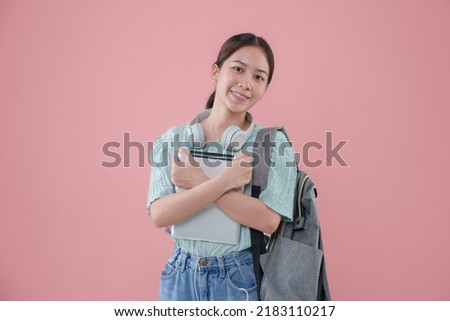 Young Asian student girl backpack pink background.
