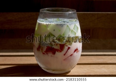 a fresh drink in a transparent glass consisting of white milk and jelly pieces