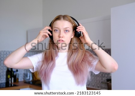 A cute caucasian teen girl listening music with wireless headphones