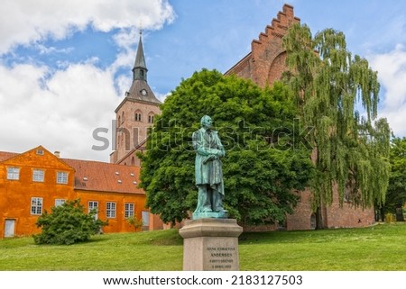 Monument from 1888 for the Danish author Hans Christian Andersen. Odense cathedral in background. Royalty-Free Stock Photo #2183127503