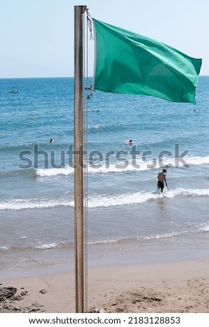 Green flag to indicate that bathing on the beach is safe. 
