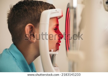 A child undergoes a corneal topographer to take information about the cornea. Optometry. Royalty-Free Stock Photo #2183141233