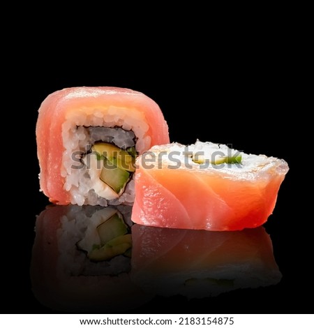 sushi roll with tuna, avocado and cream cheese on a black background.