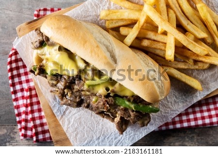 Philly cheesesteak sandwich with beef, cheese,green pepers and caramelized onion on wooden table Royalty-Free Stock Photo #2183161181